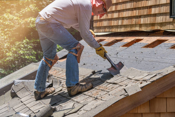 Man removing old shingles on roof. Installing new roof.